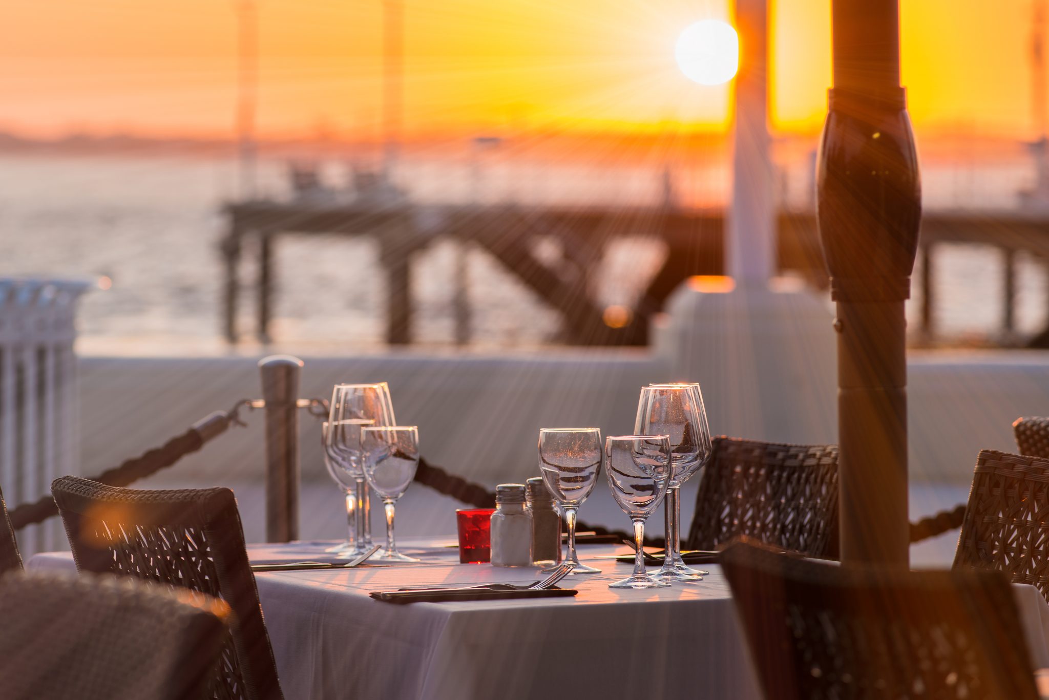 Close-up of outdoor place setting during sunset at waterfront